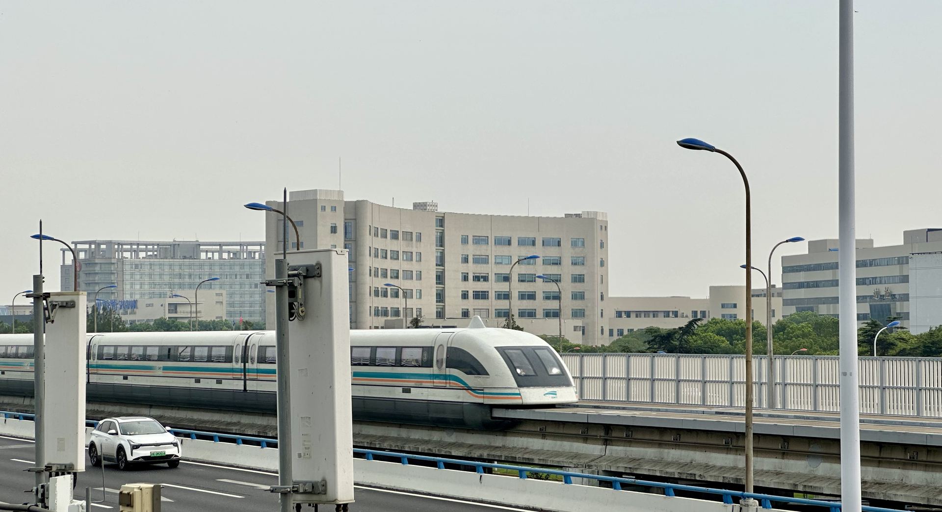 A white Shanghai maglev train gliding along its elevated guideway